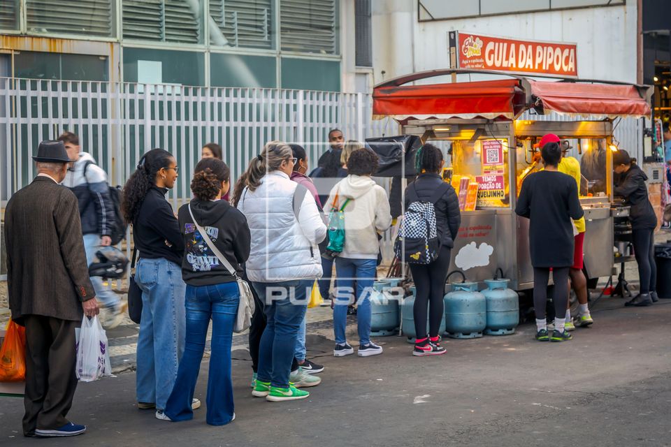 Fila de pessoas na rua para comprar pipoca 