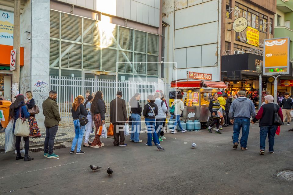 Fila de pessoas na rua para comprar pipoca 