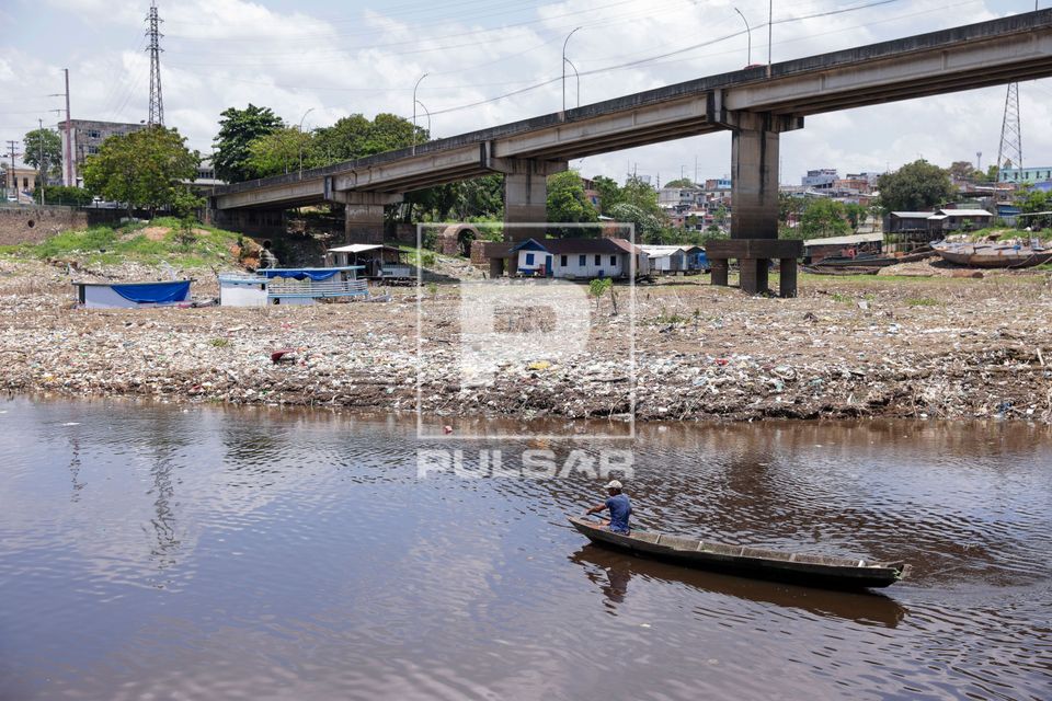Ribeirinho em canoa durante a seca do Rio Negro no bairro do São Raimundo