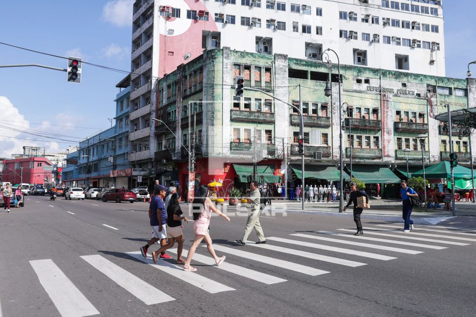Pessoas atravessando na faixa de pedestres em avenida do centro da cidade