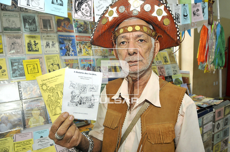 Escritor e folheteiro de literatura de cordel mostrando folhetos - 