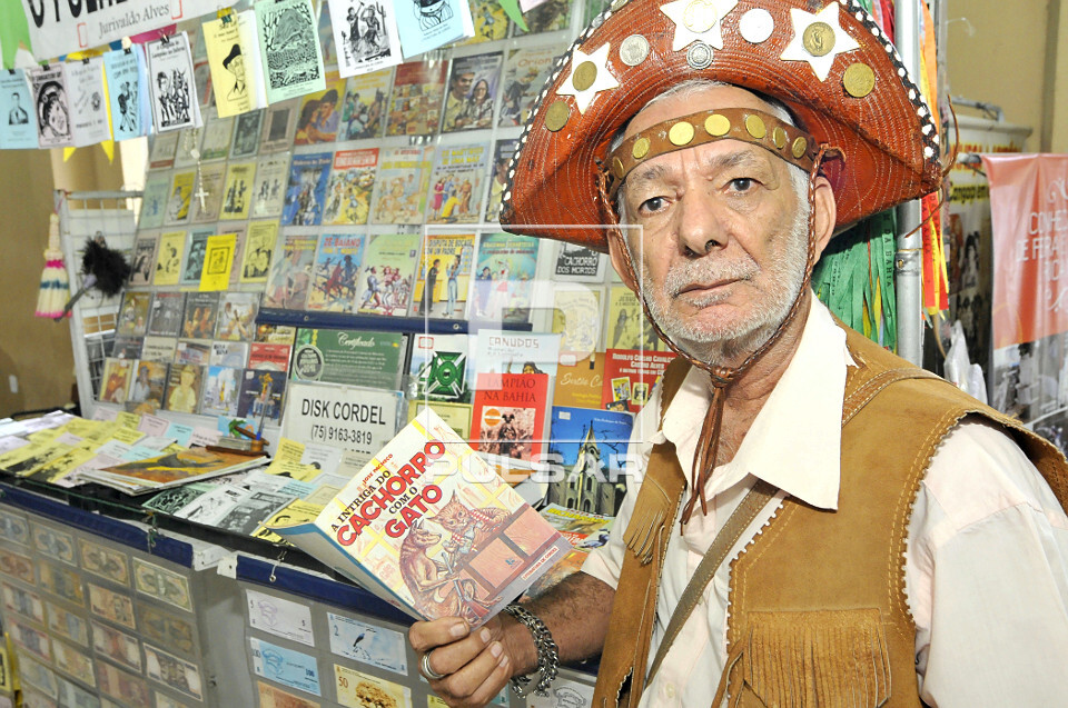 Escritor e folheteiro de literatura de cordel mostrando folheto - 