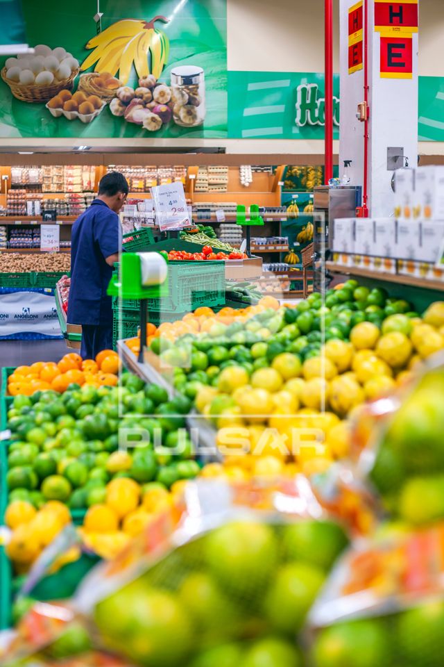 Repositor no setor de hortifruti de supermercado
