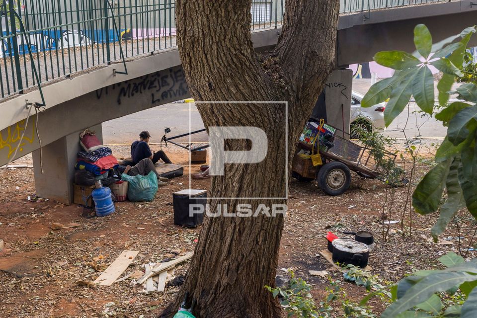 Moradores de rua descansam sob passarela de pedestres