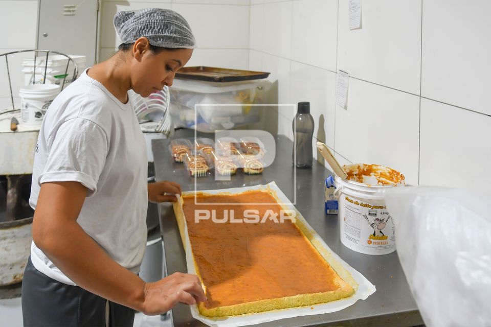 Confeiteira fazendo rocambole com recheio de doce de leite