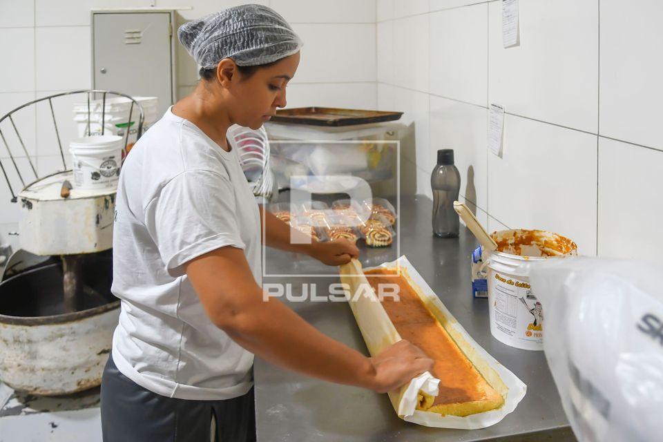 Confeiteira fazendo rocambole com recheio de doce de leite