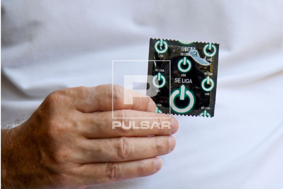 Homem segurando preservativo 