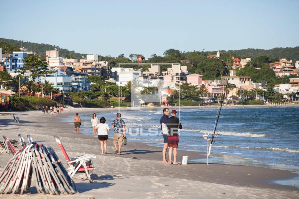 Pessoas caminhando na beira-mar na Praia de Bombinhas