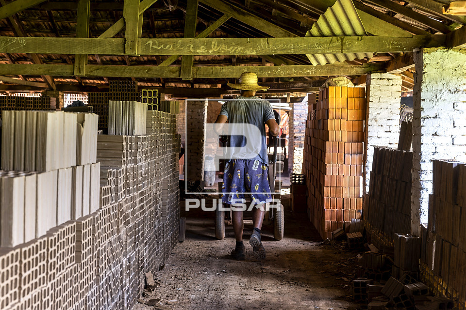 Trabalhador empurrando carrinho em olaria