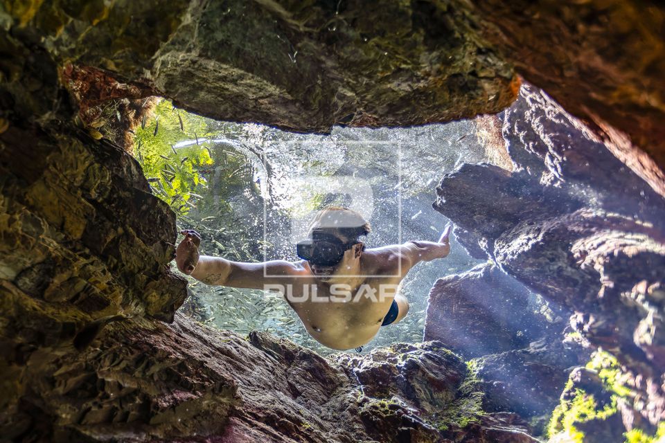 Ecoturista entrando em caverna submersa na nascente do Rio Chapeninha 