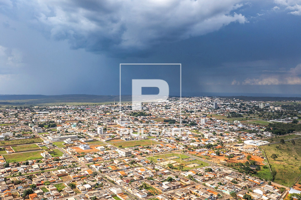 Vista de drone da cidade com chuva ao fundo - 