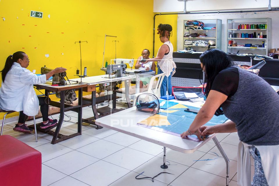 Aula de costura fabricando bolsas a partir de banners descartados na Biblioteca Parque da Rocinha - reuso 