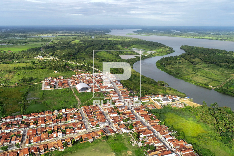 Vista de drone de moradias e canal que deságua no Rio São Francisco ...