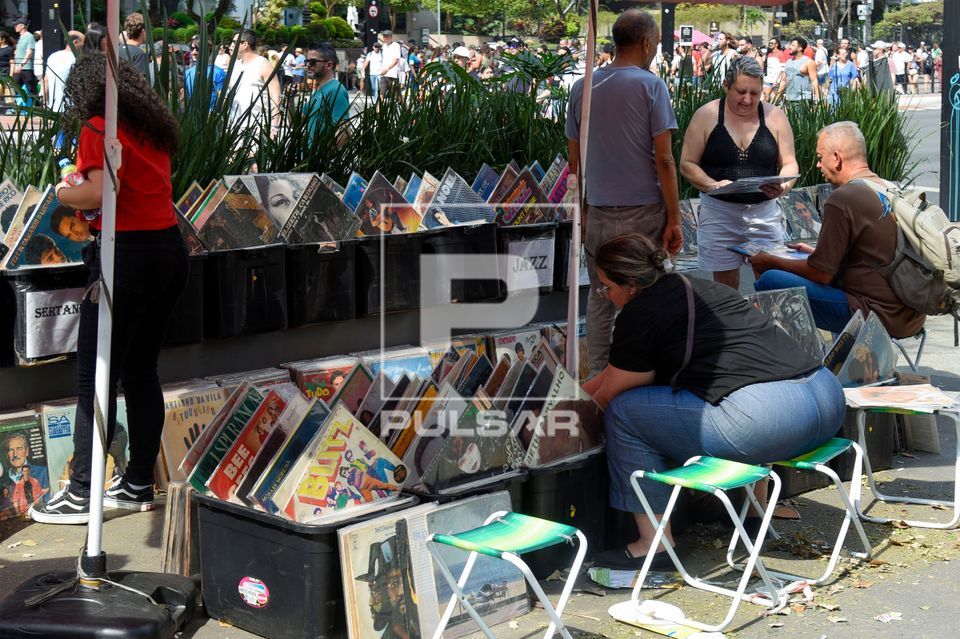 Clientes em banca de discos de vinil antigos na Avenida Paulista fechada aos domingos