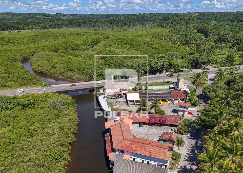 Vista de drone de hotel na beira do Rio Cururupe e Rodovia BA-001 ao fundo