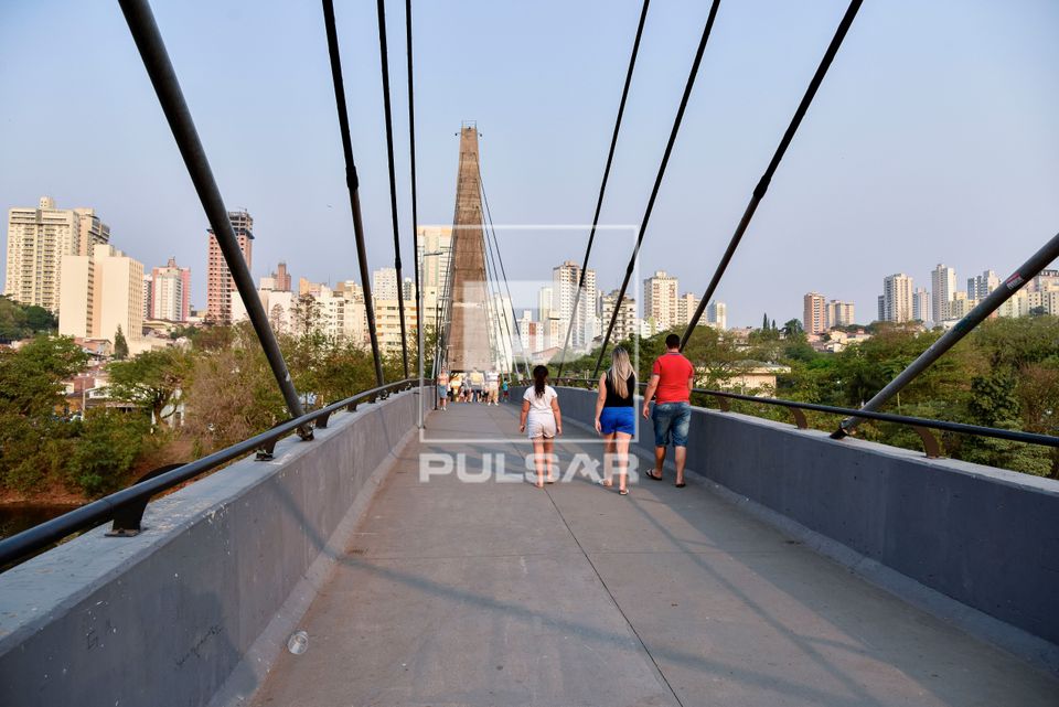 Visitantes caminhando na passarela estaiada doutor Aninoel Dias Pacheco sobre o rio Piracicaba