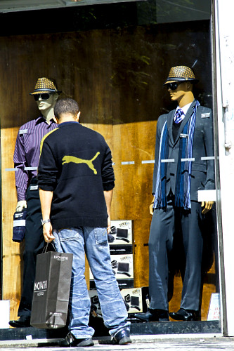 Homem olhando vitrine de loja com roupas masculinas de inverno