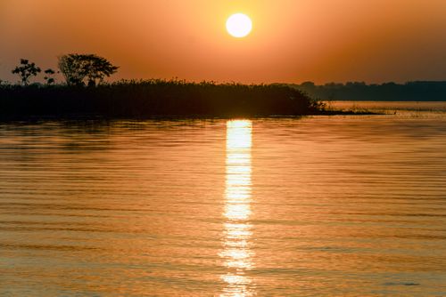 Pôr do sol refletido nas águas do Rio Paraná aqui represado pela Usina Hidroelétrica de Ilha Solteira