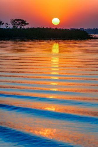 Pôr do sol refletido nas águas do Rio Paraná aqui represado pela Usina Hidroelétrica de Ilha Solteira