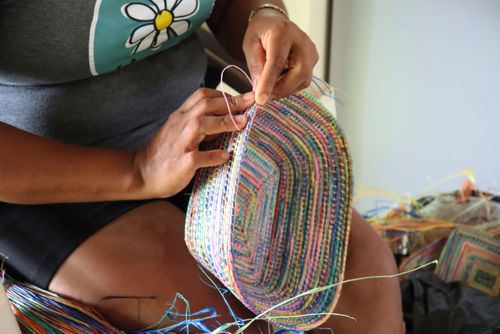 Artesã fazendo artesanato com palha do ourucuri