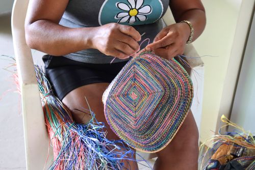 Artesã fazendo artesanato com palha do ourucuri