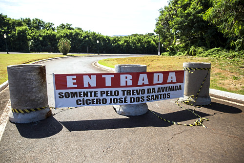 Barreiras de bloqueio na entrada da cidade em função da pandemia de coronavírus - faixa informando acesso a