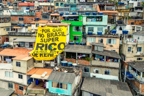 Vista de drone de moradias na Favela do Vidigal com faixa do Coletivo Alvorada - campanha pela taxação dos S
