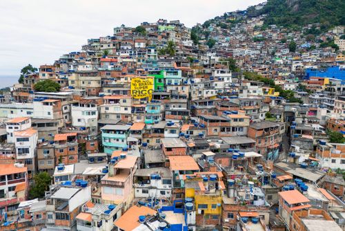 Vista de drone de moradias na Favela do Vidigal com faixa do Coletivo Alvorada - campanha pela taxação dos S