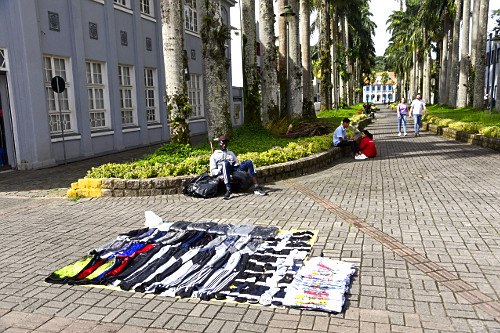 Ambulante imigrante vendendo roupas próximo à Alameda Brustlen também conhecida como Rua das Palmeiras