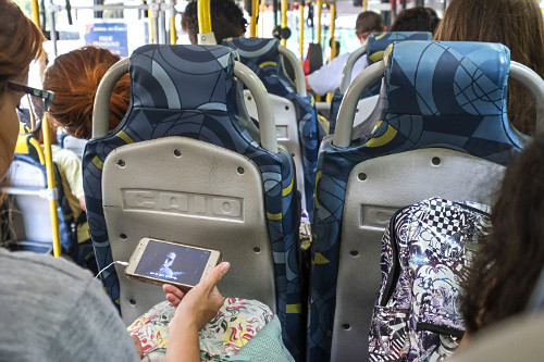 Passageira de ônibus assistindo filme pelo celular - 