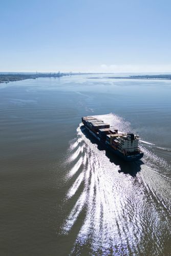 Vista de drone de navio porta contêineres entrando no porto de Rio Grande - barra da Lagoa dos Patos