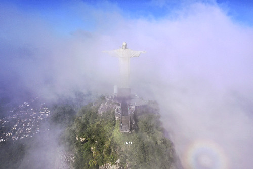 Vista de drone do Cristo Redentor no topo do morro do Corcovado com nevoeiro intenso - escultura no estilo art