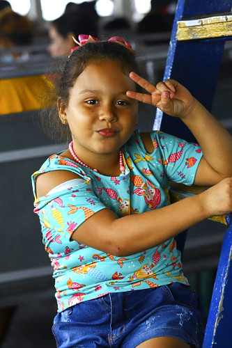 Retrato de criança sorrindo - passageira em transporte coletivo fluvial navegando na Baía do marajó com des